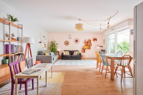 ein Wohnzimmer mit Tisch und Stühlen in der Unterkunft Grand et charmant appartement familial, 3 chambres, et moderne avec grand jardin et parking privatif aux portes de Paris in La Garenne-Colombes