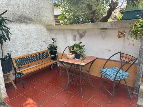 a patio with a table and a bench and a table and chairs at Vila do Covil in Tomar