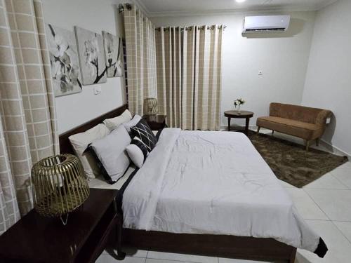 a bedroom with a large bed and a couch at Dream Villa at Oyarifa in Oyarifa