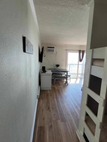 a room with a staircase and a room with a table at Steps To The Ocean! 129 in North Topsail Beach