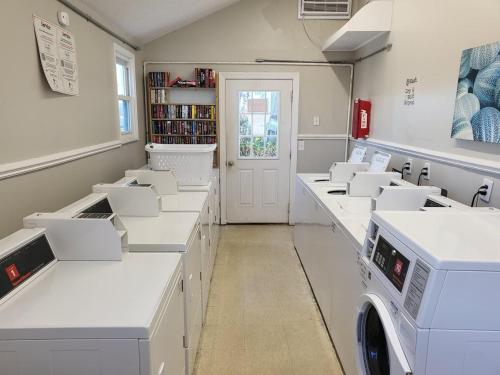 a laundry room with white counters and washing machines at Steps To The Ocean! 129 in North Topsail Beach