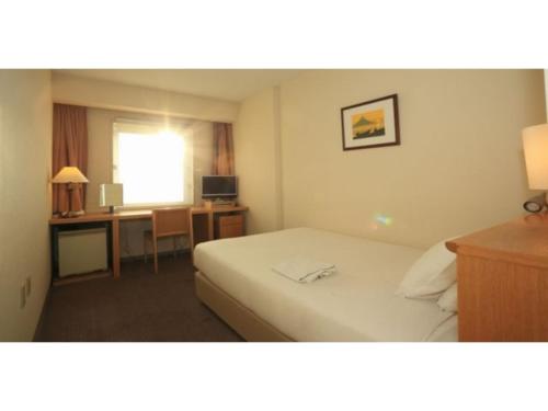 a hotel room with a bed and a desk at Smile Hotel Tomakomai - Vacation STAY 68949v in Tomakomai
