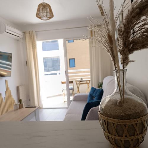 a vase with flowers sitting on a table in a living room at JR apartment albir in Albir