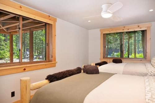 two beds in a room with two windows at Big Chief River Retreat-Located on Truckee River in Truckee