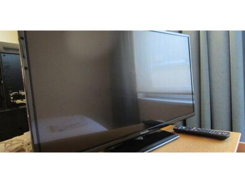 a desk with a computer monitor and a remote control at Smile Hotel Tomakomai - Vacation STAY 68898v in Tomakomai