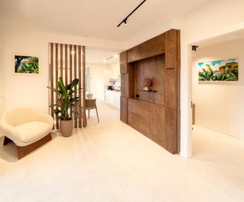 a living room with a wooden door and a chair at Cefalù Luxury Suite in Cefalù