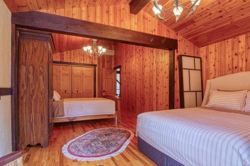 a bedroom with two beds in a room with wooden walls at Mountain Retreat, Panoramic Lake Views in Invermere