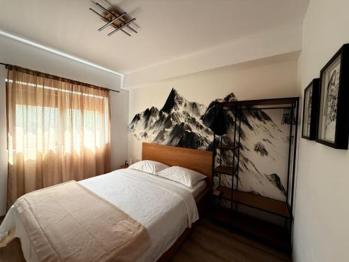 een slaapkamer met een bed met een muurschildering van de bergen bij Mountain Place to Remember - River & Barbecue in Buşteni