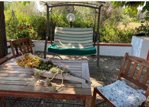 a wooden table with a gazebo and two chairs at Vendrisine lacco rosso 1436 in Casarano