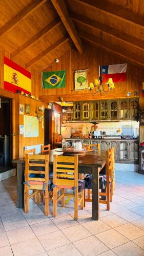 a dining room with a wooden table and chairs at Hostal el Nogal Pucón in Pucón