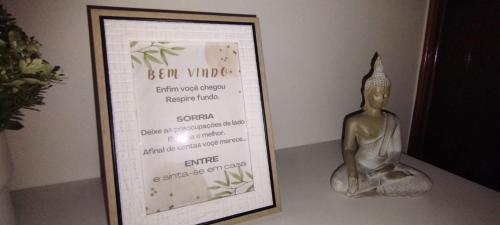 a picture of a sign with a statue next to it at Casa Flor de Mel in Sertã