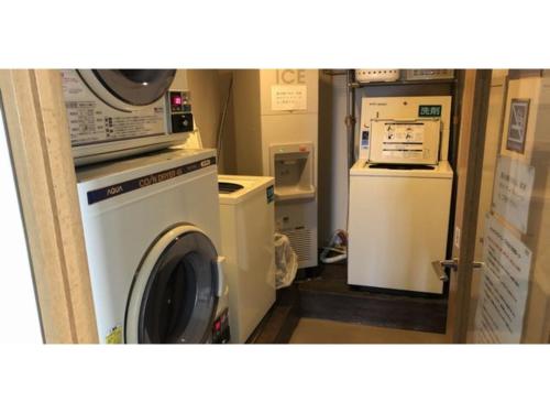 a laundry room with a washing machine and a refrigerator at Smile Hotel Tomakomai - Vacation STAY 68959v in Tomakomai