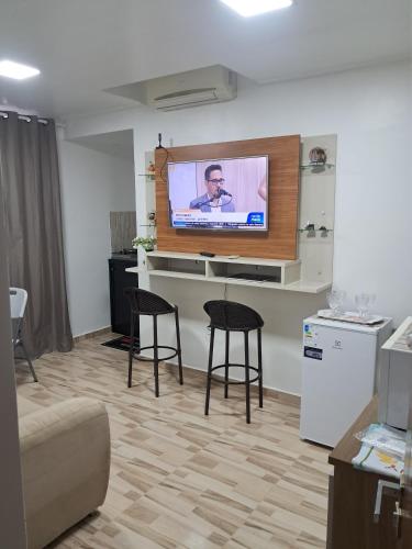 a living room with two chairs and a flat screen tv at Apartamento por temporada no centro de Macapá - mobiliado in Macapá