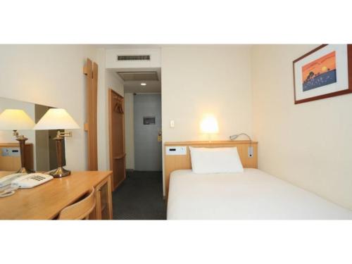 a hotel room with a bed and a desk and a room at Smile Hotel Tomakomai - Vacation STAY 68943v in Tomakomai