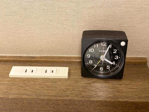 a black clock sitting on top of a wooden table at Smile Hotel Nagano - Vacation STAY 69527v in Nagano