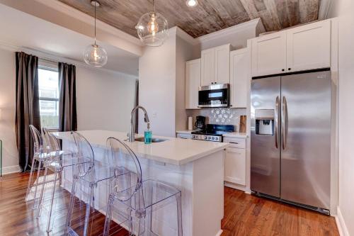 a kitchen with white cabinets and a stainless steel refrigerator at Mid-City 3BR w Pool Balcony Near Streetcar & FQ in New Orleans