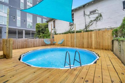 a swimming pool on a wooden deck with a blue umbrella at Mid-City 3BR w Pool Balcony Near Streetcar & FQ in New Orleans