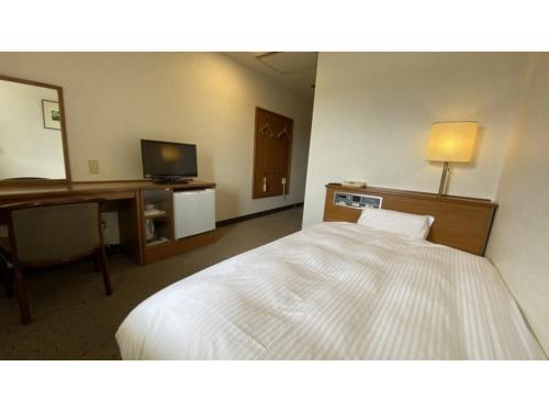 a hotel room with a bed and a desk and a television at Smile Hotel Nabari - Vacation STAY 70534v in Nabari