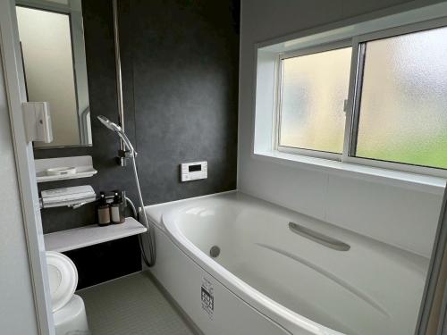 a bathroom with a white tub and a window at 8co - Vacation STAY 69979v in Chino