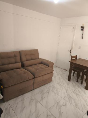 a living room with a brown couch and a table at Apartamento Life COP30 in Castanhal