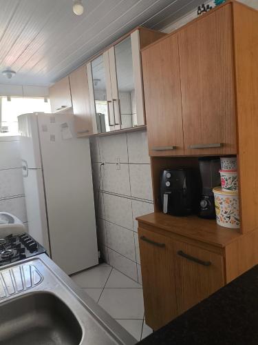 a small kitchen with a sink and a refrigerator at Apartamento Life COP30 in Castanhal
