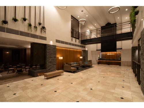 a large lobby with a waiting area with tables and chairs at HOTEL enoe Hakodate - Vacation STAY 78527v in Hakodate