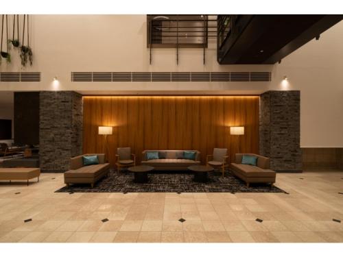 a lobby with couches and tables in a building at HOTEL enoe Hakodate - Vacation STAY 78527v in Hakodate