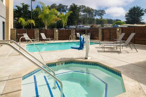 a swimming pool with chairs and a table and chairs at Fairfield Inn & Suites by Marriott Santa Cruz in Santa Cruz