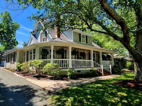 a green house with a white porch at Downtown Cary 1930s Bungalow - Great walkability in Cary
