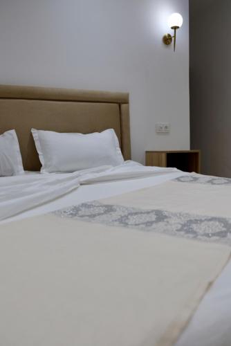 a close up of a bed with white sheets and pillows at Hôtel Ennassim in Sousse