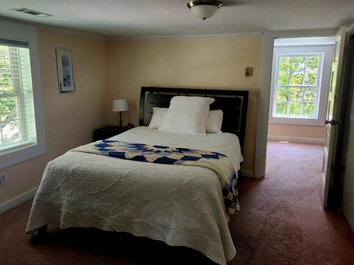 a bedroom with a large bed and two windows at Downtown Cary 1930s Bungalow - Great walkability in Cary