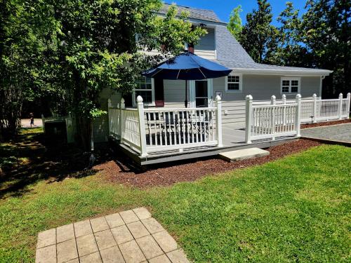 a white fence with an umbrella in front of a house at Downtown Cary 1930s Bungalow - Great walkability in Cary