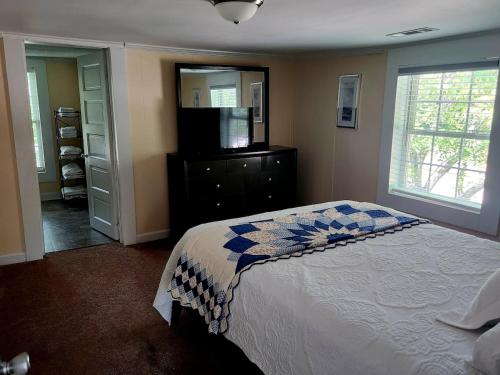 a bedroom with a bed and a flat screen tv at Downtown Cary 1930s Bungalow - Great walkability in Cary