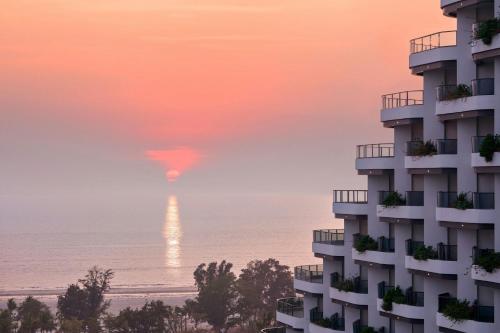 a view of a building and the ocean at sunset at Beihai Marriott Resort in Beihai