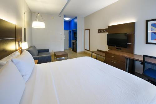 a hotel room with a large white bed and a television at Holiday Inn Express Hotel & Suites Blythewood by IHG in Blythewood