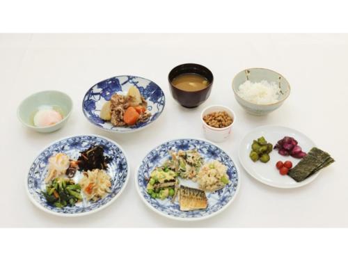 奈良市にあるSmile Hotel Nara - Vacation STAY 73745vのテーブルの上に並んだ一群の食べ物の皿