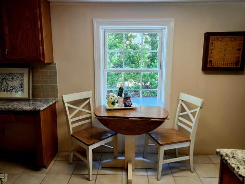 a kitchen with a table and two chairs and a window at Downtown Cary 1930s Bungalow - Great walkability in Cary