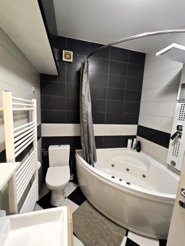 a bathroom with a tub and a toilet and a sink at Sunny River BL in Banja Luka