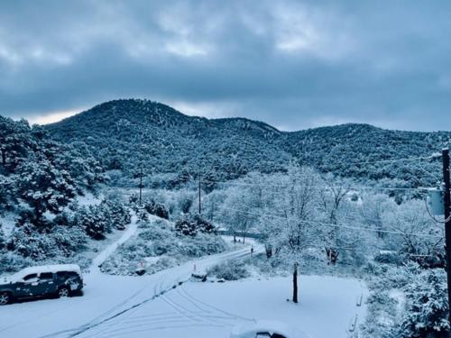 a car is driving down a snow covered road at Cloudcroft Hostel in Cloudcroft
