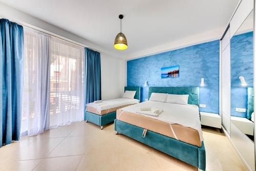 1 Schlafzimmer mit 2 Betten und blauen Wänden in der Unterkunft Lotos -apart 209 L1 in Dobra Voda