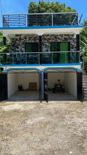 a house with a garage with a balcony on top at The apartment poso in Punta Balandra