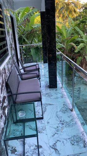 two chairs on a balcony with a glass table at The apartment poso in Punta Balandra
