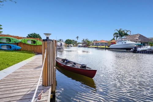 a small boat is docked next to a dock at Waterfront Retreat Home Dania Beach in Dania Beach