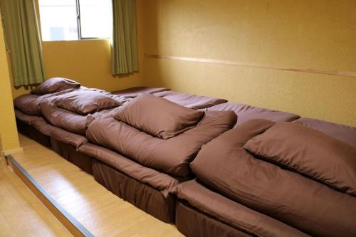 - une rangée d'oreillers dans un lit dans l'établissement Sun Sea Cottage - Vacation STAY 75054v, à Tagawa