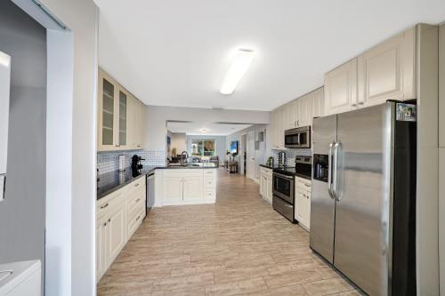 a kitchen with white cabinets and stainless steel appliances at Waterfront Retreat Home Dania Beach in Dania Beach