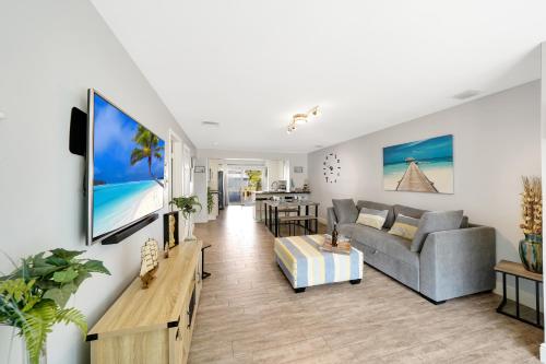 a living room with a couch and a tv on a wall at Waterfront Retreat Home Dania Beach in Dania Beach