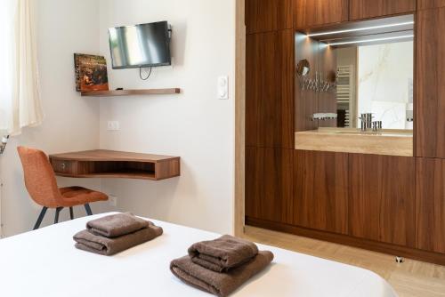 a bedroom with a bed with two towels on it at Les Sorbiers & spa in Saint-Avertin