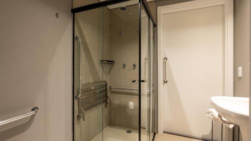 una doccia in vetro in un bagno con lavandino di Studios luxuosos ao lado do Shooping Frei Caneca a San Paolo