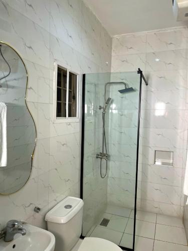 a bathroom with a shower and a toilet and a sink at Woodhaven apartment in Kubwa