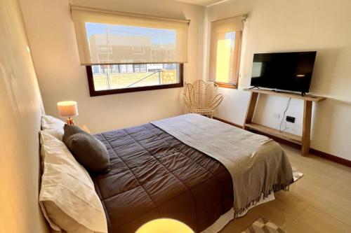 ein Schlafzimmer mit einem Bett und einem Flachbildfernseher in der Unterkunft LUXURY Casa cerca al centro en El Calafate Glacial, Argentina in El Calafate